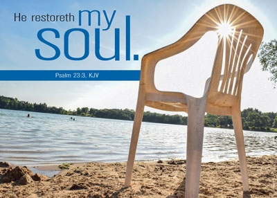 Color photo image of a chair on a beach at the water's edge